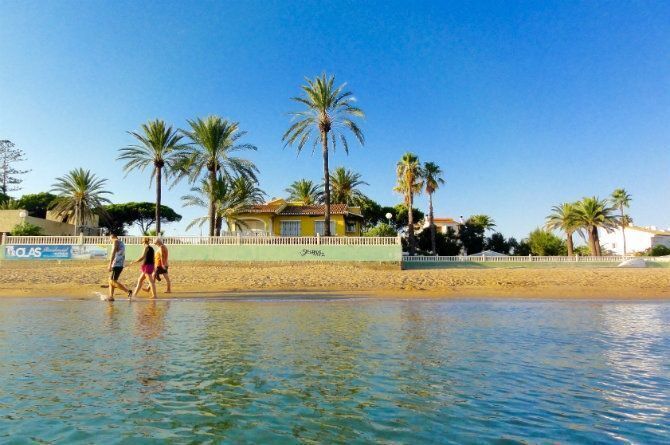 Imagen facilitada por los vecinos, el muro del chalet, la playa y el cartel que anuncia la promoción